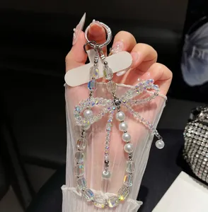 Detalle de correa para móvil con lazo de perlas y cristales brillantes de lujo