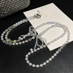 Detalle de correa de lujo para teléfono con perlas, cuentas de colores y lazo de cristal
