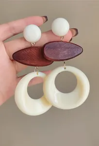 Detail of vintage French resin and wood earrings with cream hollow ring and brown oval.