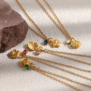 Primer plano de collares con colgantes de flores bañados en oro de 18K y piedras