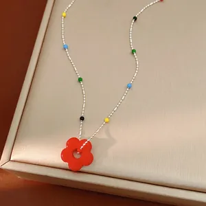 Collier avec pendentif fleur en verre et perles colorées sur chaîne argentée