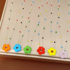 Gros plan détaillé de pendentifs fleurs en verre coloré vibrants sur des chaînes à billes argentées