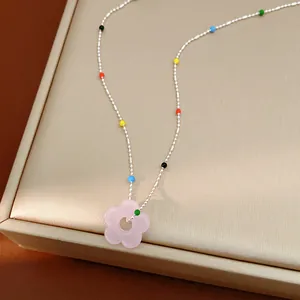 Vue détaillée d'un collier fleur en verre dopamine coloré avec une chaîne à billes argentée