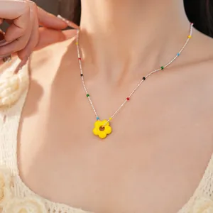 Gros plan détaillé du collier avec pendentif fleur en verre coloré sur le cou du mannequin