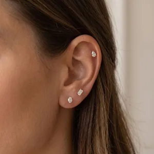 Close-up of stainless steel geometric earring set featuring water drop and baguette studs