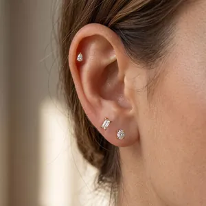 Elegant gold-plated stud earring set with pear, baguette, and round crystals on ear