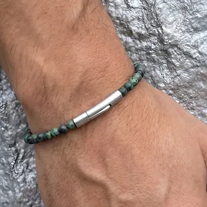 Primo piano dettagliato del bracciale di perle in pietra naturale con chiusura metallica al polso