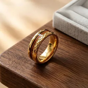 Détail d'une bague en acier inoxydable doré avec incrustation en bois et bords facettés