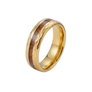 Vue détaillée d'une bague en acier doré avec insert bois et texture martelée