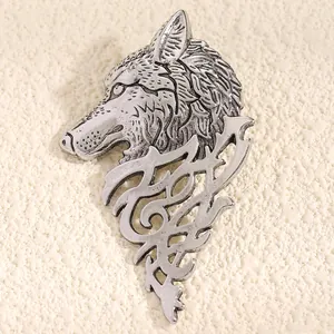 Detailed view of vintage silver wolf head lapel pin with intricate tribal scrollwork