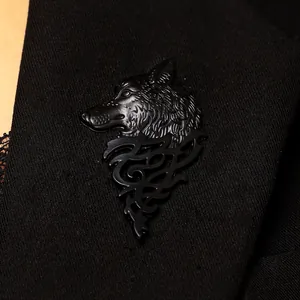 Macro detail of a vintage matte black wolf head brooch pinned on black suit fabric