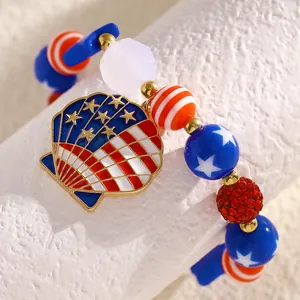 Macro detail of Independence Day bracelet featuring American flag shell charm and star beads.