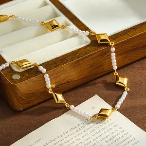 Primer plano de un collar de acero inoxidable dorado con rombos y perlas blancas