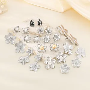Elegant collection of silver textured floral earrings featuring faux pearls on a stone base
