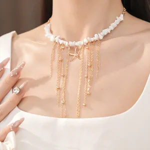 Dettaglio della collana in pietre bianche con ciondolo stella marina e nappe dorate