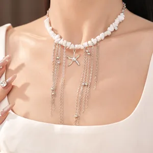 Dettaglio di collana in pietre bianche con stella marina d'argento e nappe