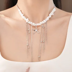 Dettaglio della collana di perline con ciondolo stella marina e nappe argento su collo