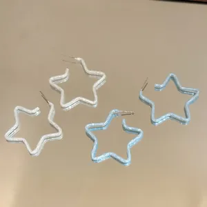 Dettaglio di orecchini a cerchio a stella con finitura a vernice stropicciata bianco e blu.