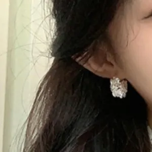 Eleganti orecchini a cerchio a cesto di fiori in argento con perle su modella asiatica
