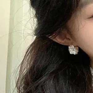Primo piano di orecchini a cerchio a cesto di fiori in argento con zirconi scintillanti