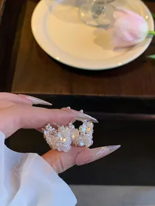 Primo piano di orecchini a cesto di fiori con perle delicate e zirconi luccicanti