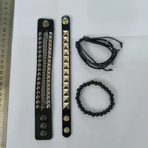 Dettaglio del set di 4 bracciali punk da uomo con borchie e righello per riferimento taglia