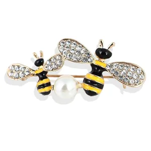 Elegante spilla a doppia ape in lega con strass scintillanti e una grande perla bianca