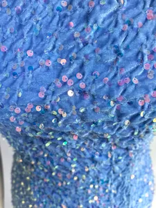 Nahaufnahme eines hellblauen Cocktailkleids mit glitzernden Pailletten und Faltenstruktur
