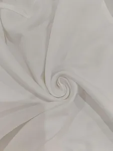 Detailed close-up of soft white fabric texture showing delicate weave and smooth drape