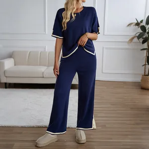 Navy blue two-piece knit set with contrast trim featuring short sleeve top and wide leg pants