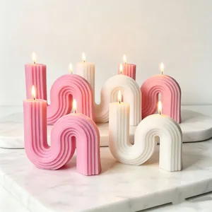 Elegant minimalist S-shaped and arched ribbed scented candles on marble tray for home decor