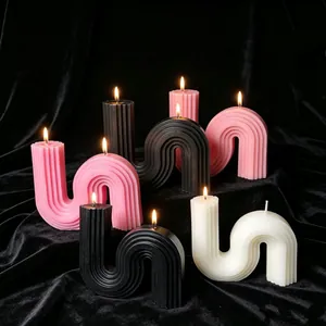 Modern S-shaped geometric scented candles in pink black and white on black velvet
