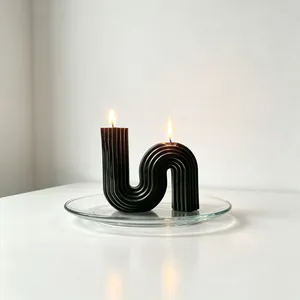 Detailed view of a black geometric S-shaped scented candle with vertical grooves.