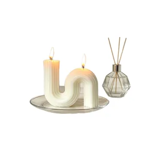 Elegant S-shaped white geometric scented candle with double wicks on a glass tray