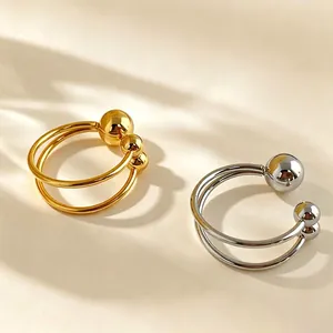 High-quality detail of minimalist gold and silver titanium steel open rings with steel balls
