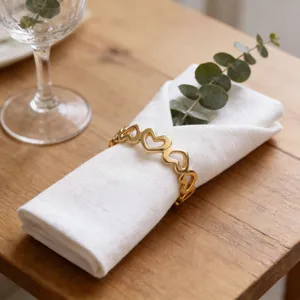 Rond de serviette élégant en métal doré en forme de cœur pour table de Saint-Valentin.