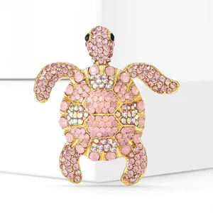 Detailed view of a pink rhinestone turtle brooch with golden alloy frame and AB crystals