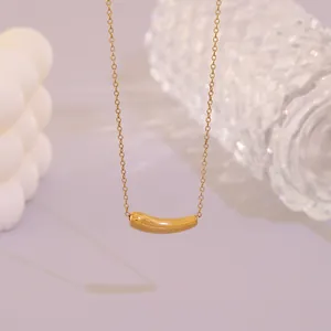Nahaufnahme einer goldenen Edelstahlkette mit minimalistischem, gebogenem Anhänger.