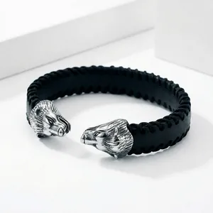 Close-up of punk style stainless steel bracelet with black leather and bear head details.