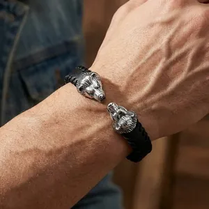 Close-up detail of a men's punk leather bracelet with dual silver lion head steel charms.