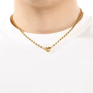 Dettaglio di una collana a sfere in acciaio dorato con un ciondolo a cuore magnetico.
