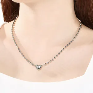 Primo piano di una collana a sfere in acciaio argento con chiusura a cuore magnetico.
