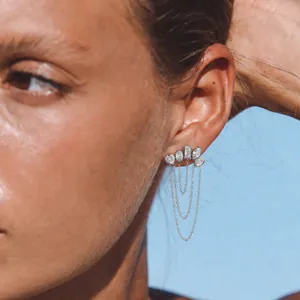 Macro detail of elegant silver tassel earrings with sparkling white zircons on a model