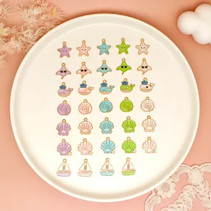 Collection of colorful ocean-themed enamel charms displayed on a white plate