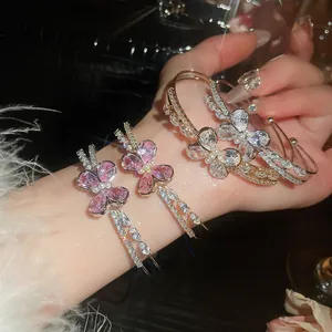 Close-up detail of elegant double-layer zircon butterfly open bracelets worn on wrist.