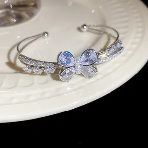 Detail showing the sparkling zirconia butterfly and pearl center on the double-layer cuff