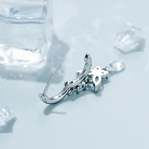 Elegante pendiente de mariposa plateado con colgante de circón sobre fondo azul hielo