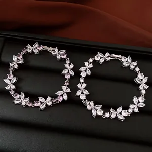 Detailed view of floral cubic zirconia bracelets with pink and clear stones on black tray