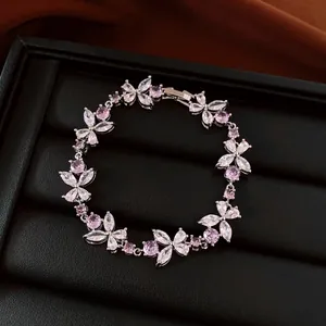Detailed view of French luxury silver bracelet with pink zircon flower charms