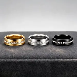 Detail view of three stainless steel rings in gold, silver, and black with inlaid crystals